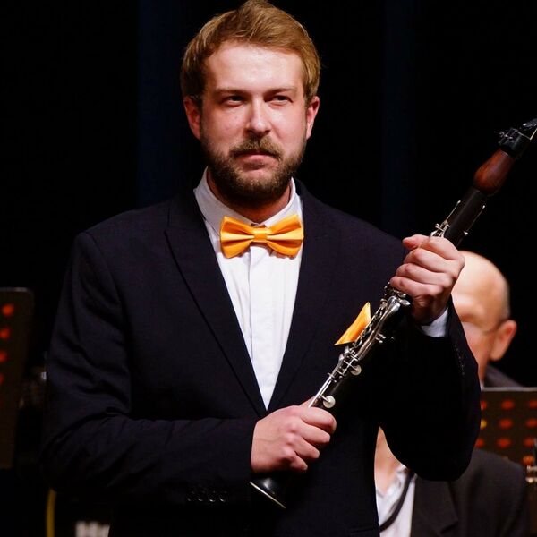 Высокий блондин с кларнетом и оркестром